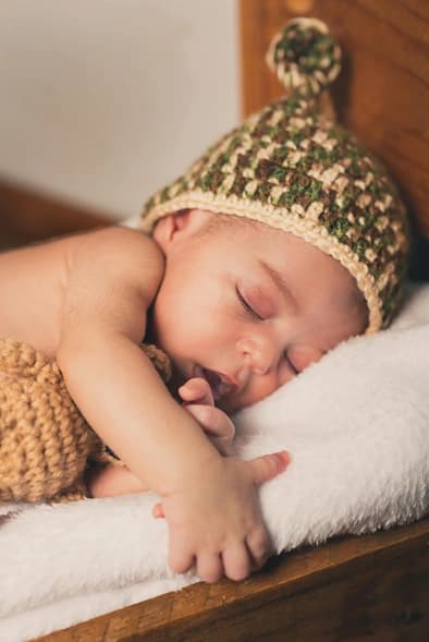 Vredig slapende pasgeboren baby tijdens de kraamweek in Zaandam
